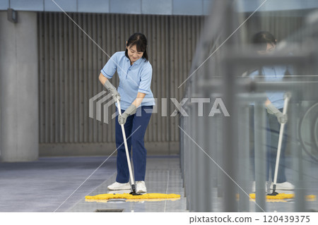 Image of building cleaning: Middle-aged female cleaning staff mopping the floor 120439375