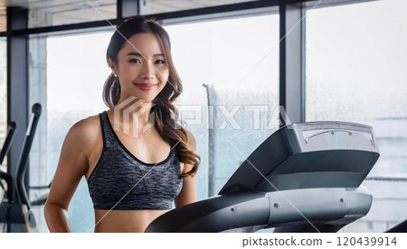 Young woman exercising on a running machine 120439914