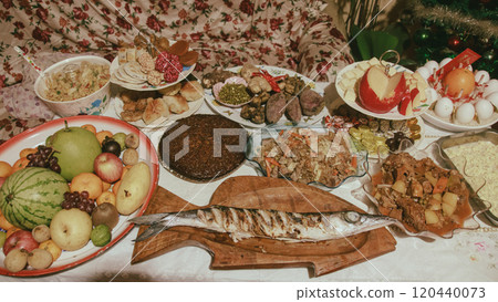 A table filled with various fruits, grilled fish, pansit, biko and other authentic local Filipino dish and desserts for a traditional New Year's Eve feast or Media Noche in the Philippines 120440073