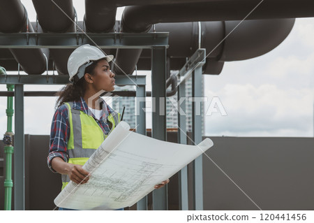 Engineers with draft plan of building on constructing site. Engineer working on building site. Engineer working with drawing System plan document 120441456