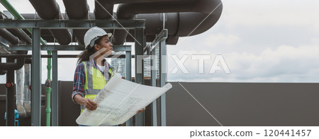 Engineers with draft plan of building on constructing site. Engineer working on building site. Engineer working with drawing System plan document Engineers with draft plan of building on constructing site. Engineer working on building site. Engineer working with drawing System plan document 120441457