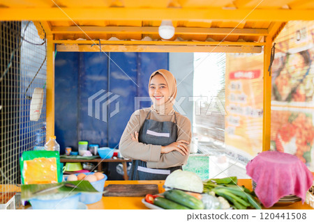A vendor displays vibrant vegetables at a bustling food stall, showcasing fresh produce A vendor displays vibrant vegetables at a bustling food stall, showcasing fresh produce 120441508