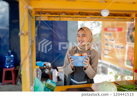 A Friendly Vendor Smiling Happily with Fresh Eggs at a Local Market Stall A Friendly Vendor Smiling Happily with Fresh Eggs at a Local Market Stall 120441513