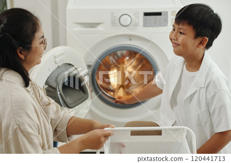 Mother and Son Doing Laundry Together at Home 120441713