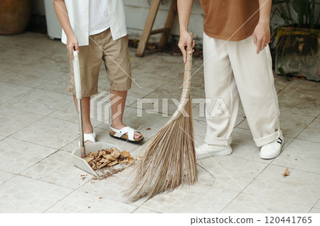 Sweeping Leaves with Broom and Dustpan in Outdoor Space 120441765