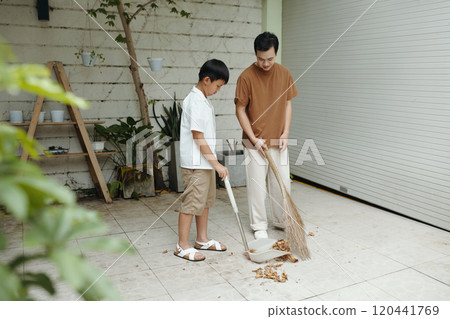 Teaching Boy Sweeping Skills in Outdoor Garage Area Teaching Boy Sweeping Skills in Outdoor Garage Area 120441769