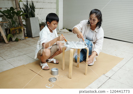 Mother and Son Painting Stool in Home Workshop Mother and Son Painting Stool in Home Workshop 120441773