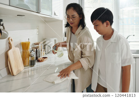 Mother Teaching Son Cooking Techniques in Modern Kitchen 120441813