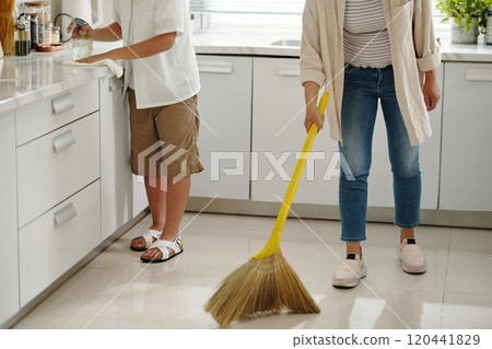 Cleaning Kitchen Together with Broom and Water Glass 120441829