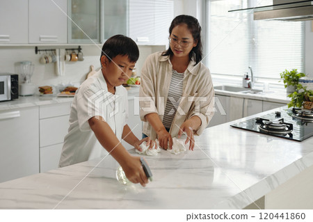 Teaching Household Chores to Young Boy in Kitchen 120441860