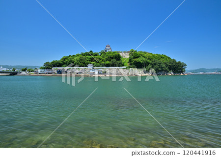 View of Karatsu Castle's castle tower and stone walls against the blue sky View of Karatsu Castle's castle tower and stone walls against the blue sky 120441916