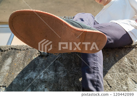Soles of a man sitting on a stone Soles of a man sitting on a stone 120442099