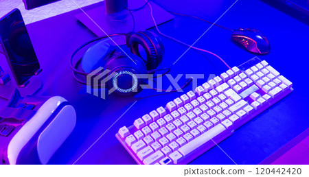 Close up gamer work space gaming set up modern equipment on desk, gaming gear, mouse, headset, computer mouse ready for online streaming 120442420