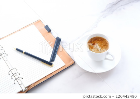 Image of a man working at his desk with a system organizer while drinking a cafe latte, a coffee with plenty of milk 120442480