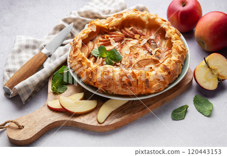 Delicious homemade apple galette with almond flakes and fresh mint on rustic background 120443153