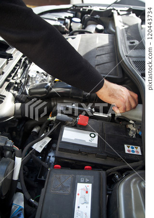 Hands of a Caucasian car mechanic performing a general check of the car's engine compartment Hands of a Caucasian car mechanic performing a general check of the car's engine compartment 120443734