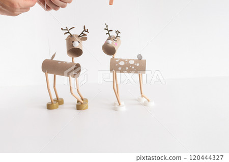 Easy DIY reindeer marionette from toilet paper roll and recycled materials for kids. Perfect craft idea for children. Creative homemade toy project 120444327