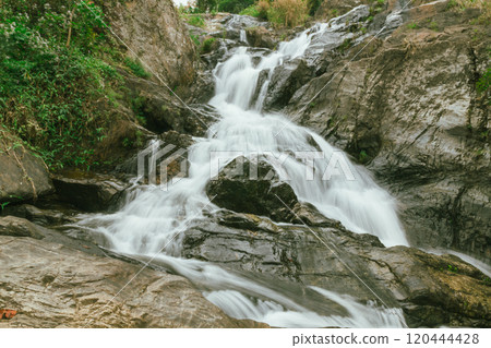 waterfall in summer scene, bright sunrise shining on the waterfall 120444428