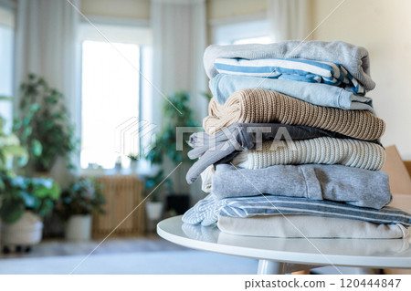 Pile of clothes in cardboard box donating for recycling reusing at living room with houseplant 120444847