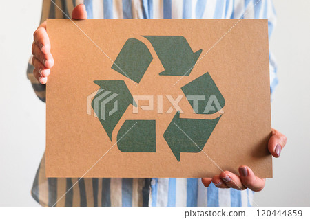 Female hands holding signboard recycling reusing zero waste circular arrow go green closeup 120444859