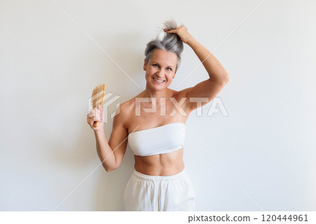 Beautiful gray haired mature woman making hairstyle haircomb posing isolated on white background 120444961
