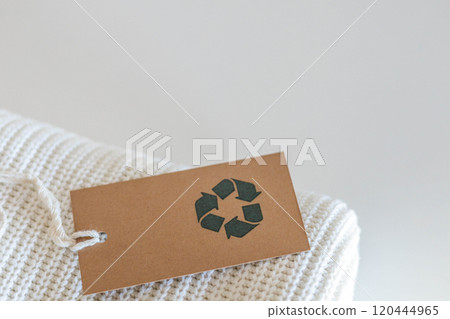 Soft knitted folded sweater recycled made by reusing material craft tag top view isolated on white Soft knitted folded sweater recycled made by reusing material craft tag top view isolated on white 120444965