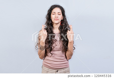 Hopeful woman making a wish isolated, Superstitious people making a wish. Worried girl crossing her fingers making a wish Hopeful woman making a wish isolated, Superstitious people making a wish. Worried girl crossing her fingers making a wish 120445316