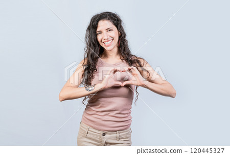 Smiling young woman making heart shape with her hands. Teen girl making heart shape with her hands, Happy girl making heart shape with hands isolated Smiling young woman making heart shape with her hands. Teen girl making heart shape with her hands, Happy girl making heart shape with hands isolated 120445327
