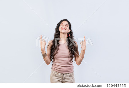 Young girl pointing an advertisement with fingers up. Smiling woman pointing with both fingers up isolated. People recommending with fingers up 120445335