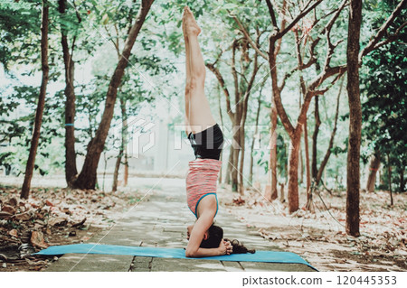 Young woman doing headstand yoga outdoors. Spiritual girl practicing yoga sirshasana outdoors. Young woman doing headstand yoga outdoors. Spiritual girl practicing yoga sirshasana outdoors. 120445353