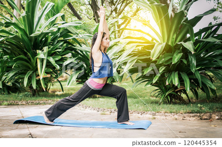 Woman doing yoga outdoors, A girl performing flexibility yoga, young girl showing yoga styles outdoors, yoga and fitness concept 120445354