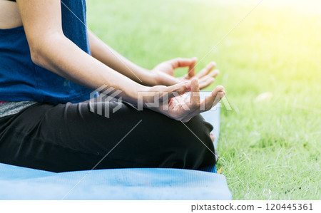 Close up of hands of a girl doing meditation yoga outdoors, Close up of hands doing yoga on the grass 120445361
