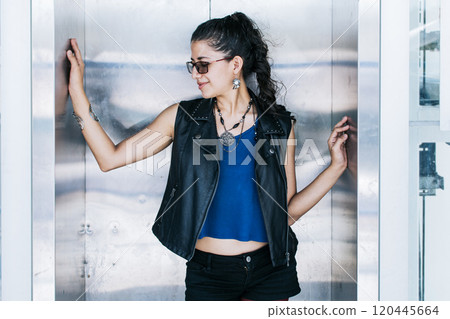 Close up of an attractive girl in an elevator, Portrait of an urban girl in an elevator, Attractive girl in glasses at the elevator door 120445664