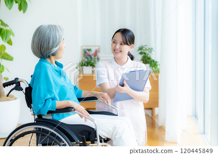Caregiver supporting a woman in a wheelchair 120445849