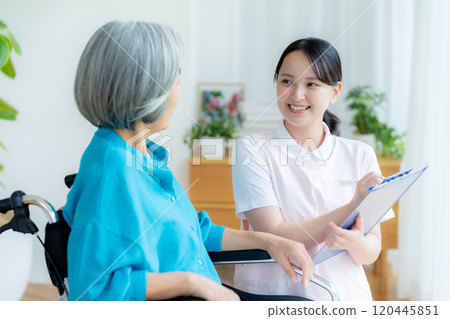 Caregiver supporting a woman in a wheelchair Caregiver supporting a woman in a wheelchair 120445851