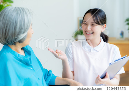 Caregiver supporting a woman in a wheelchair Caregiver supporting a woman in a wheelchair 120445853