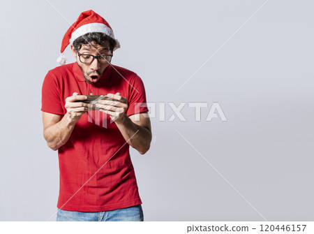 Surprised people watching a christmas promotion on the phone. Amazed man looking at a christmas offer online, Guy looking at a christmas promo on phone. Online christmas special offers concept 120446157