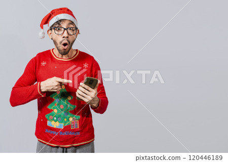Amazed man pointing at christmas offer online, Guy pointing at christmas promotion on phone. Online Christmas special offers concept, amazed people pointing at a Christmas promotion on phone Amazed man pointing at christmas offer online, Guy pointing at christmas promotion on phone. Online Christmas special offers concept, amazed people pointing at a Christmas promotion on phone 120446189