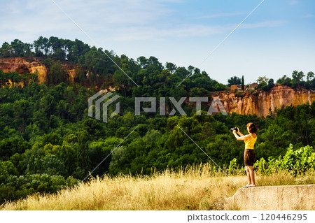 Woman take photo from red rocks in Roussillon, Provence France 120446295