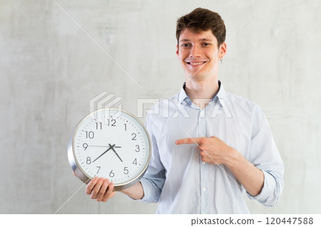 Man with a round big clock in his hands expresses various emotions 120447588