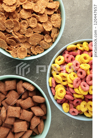 Variety of cereals in blue bowls, quick breakfast on grey background. Vertical photo Variety of cereals in blue bowls, quick breakfast on grey background. Vertical photo 120447657
