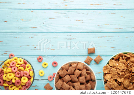 Variety of cereals in blue bowls, quick breakfast on blue wooden background. Vertical photo 120447678