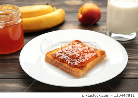 Sweet toasts with jam with milk for breakfast on grey table Sweet toasts with jam with milk for breakfast on grey table 120447911