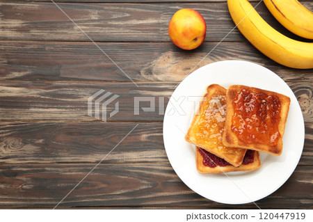 Sweet toasts with jam and fruit for breakfast on brown, horizontal Sweet toasts with jam and fruit for breakfast on brown, horizontal 120447919