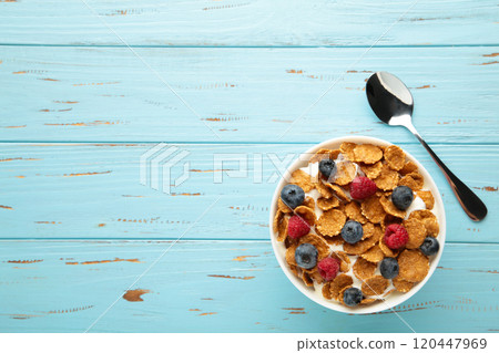 Breakfast with corn flakes, milk and berry on blue background. Vertical photo 120447969