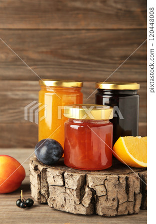 Assortment of jams, seasonal fresh berries and fruits on grey background. Assortment of jams, seasonal fresh berries and fruits on grey background. 120448008