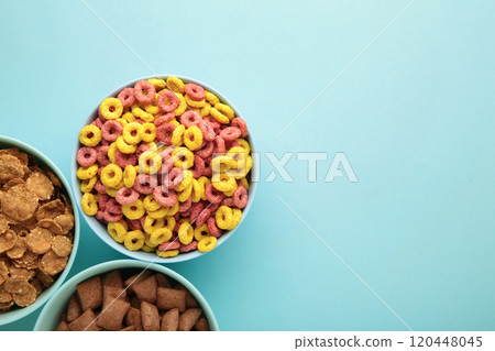 Variety of cereals in blue bowls, quick breakfast on blue background. Vertical photo Variety of cereals in blue bowls, quick breakfast on blue background. Vertical photo 120448045