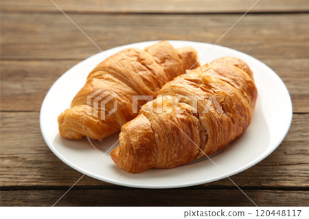 Freshly croissant on plate on grey wooden background Freshly croissant on plate on grey wooden background 120448117