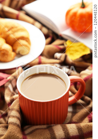 Hot coffee with croissant and autumn leaves on plaid - seasonal relax concept. Vertical photo 120448120