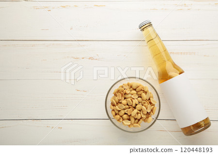 Glass of beer with peanuts on white wooden background. Glass of beer with peanuts on white wooden background. 120448193